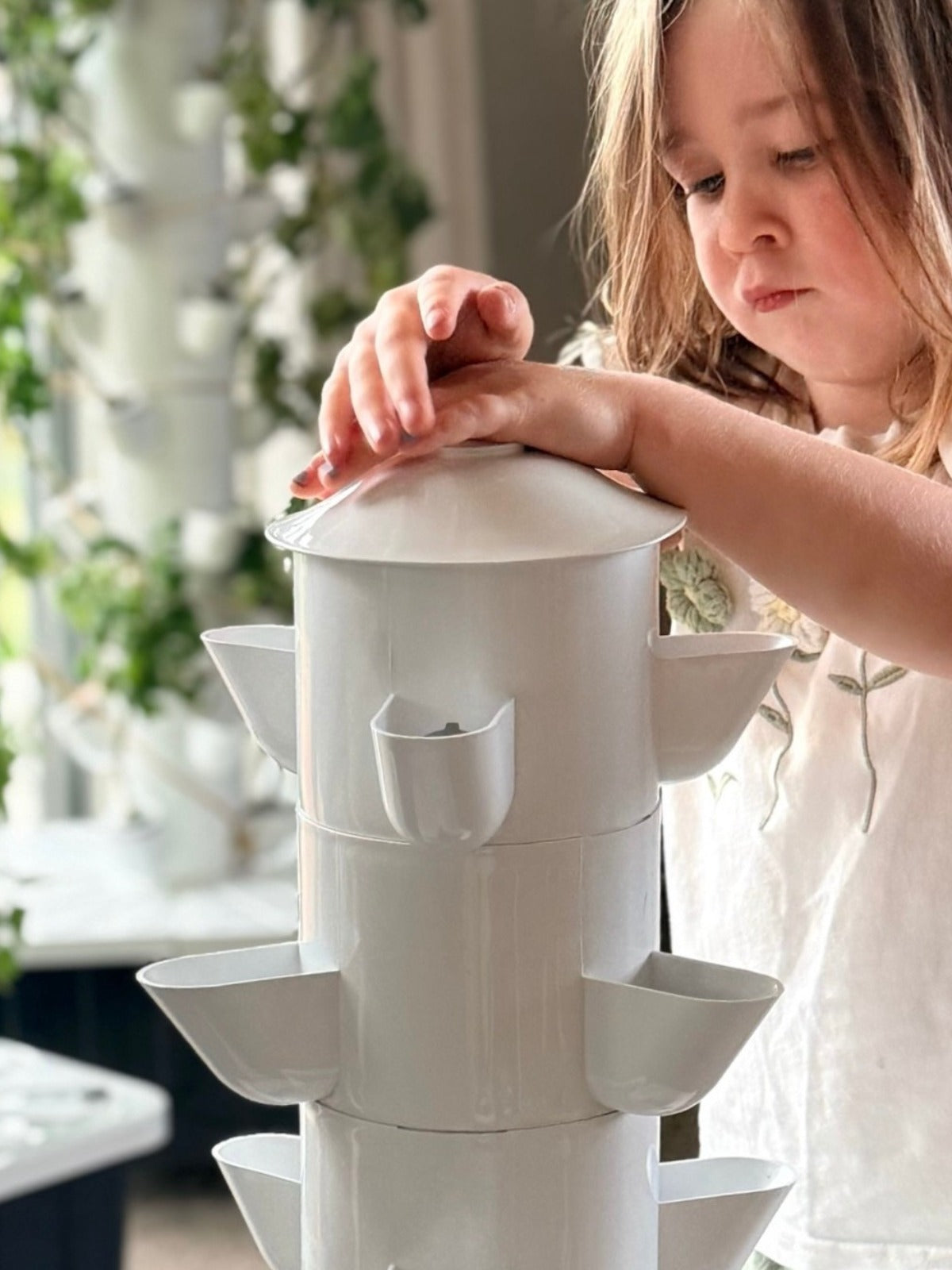 A child standing in front of the FlowGrow Vertical hydroponic system in a New Zealand home.