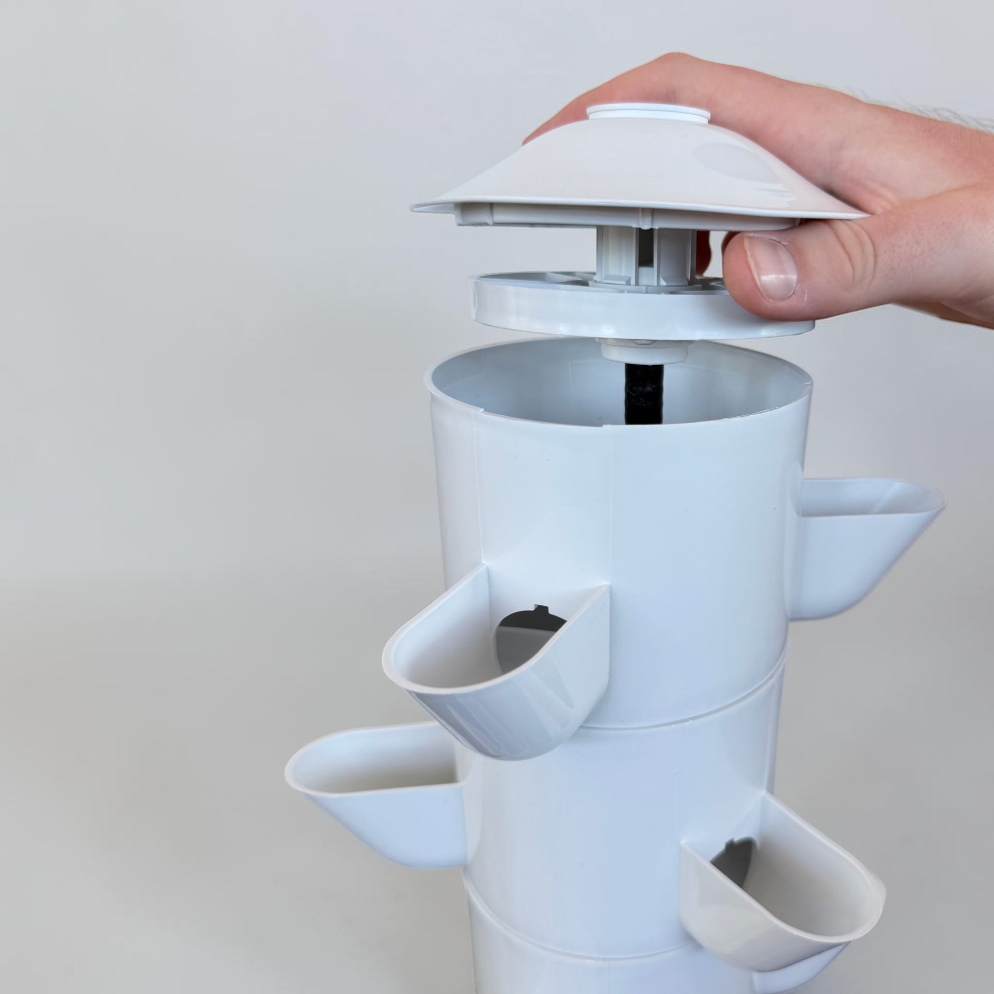 Close-up of FlowGrow flow cap being removed from hydroponic tower