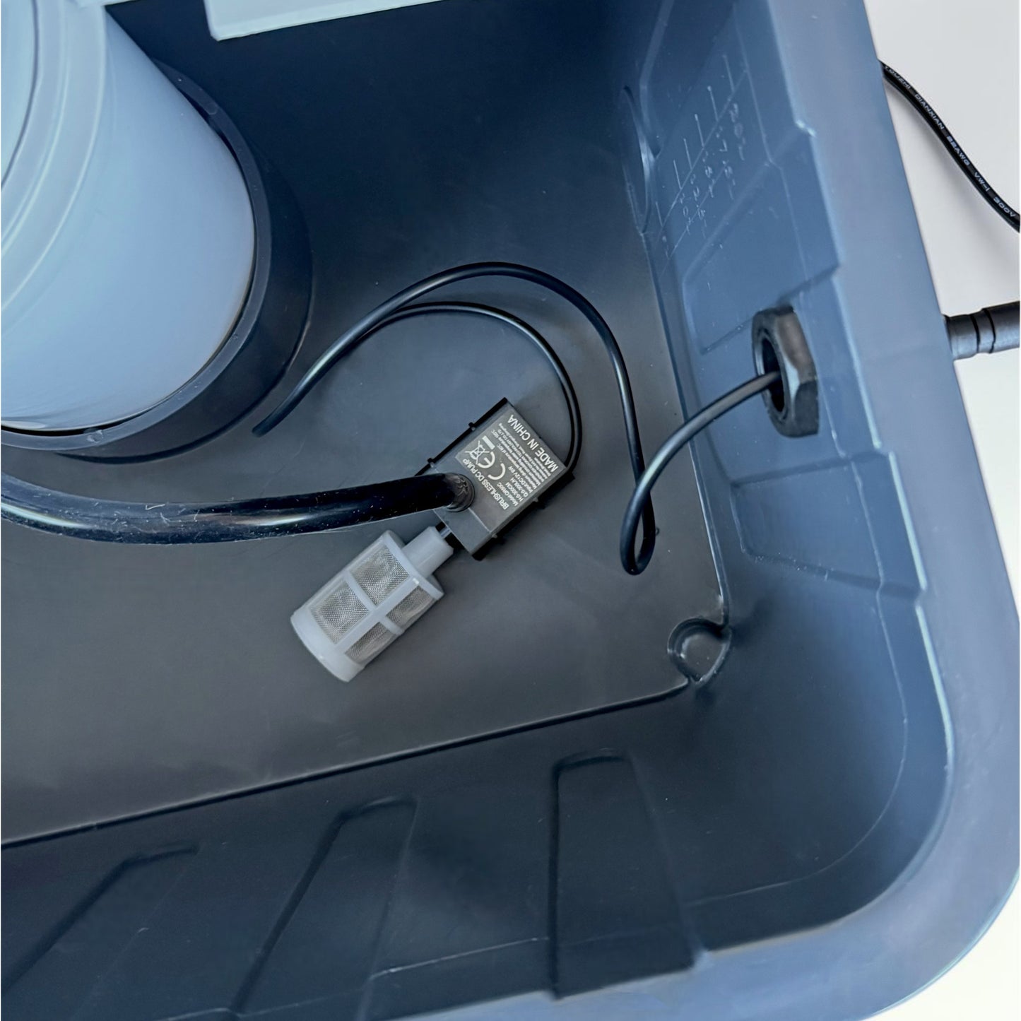 FlowGrow water pump connected to hose inside hydroponic tower reservoir